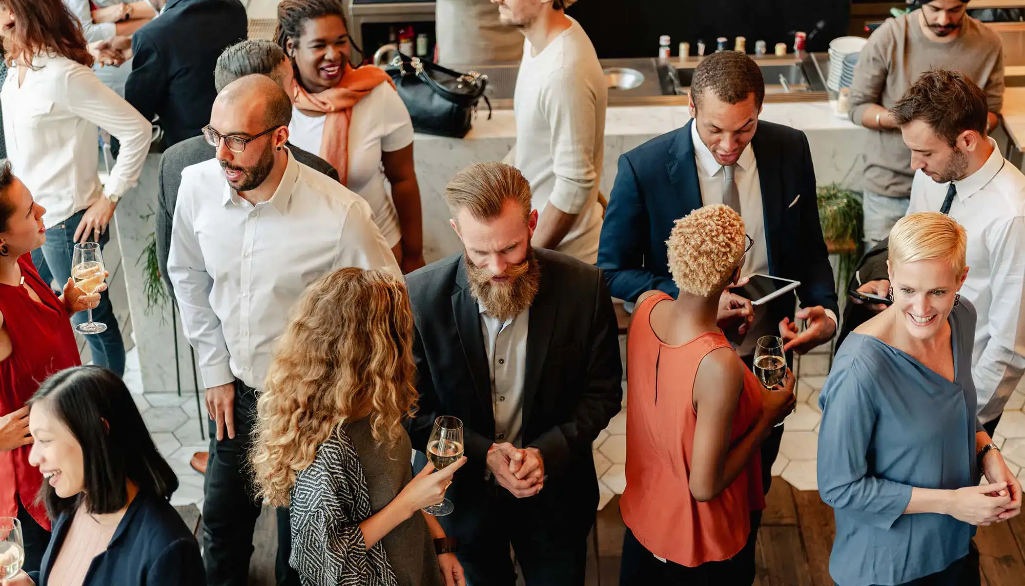 Grupo de personas conversando y sonriendo en una reuni&oacute;n social.