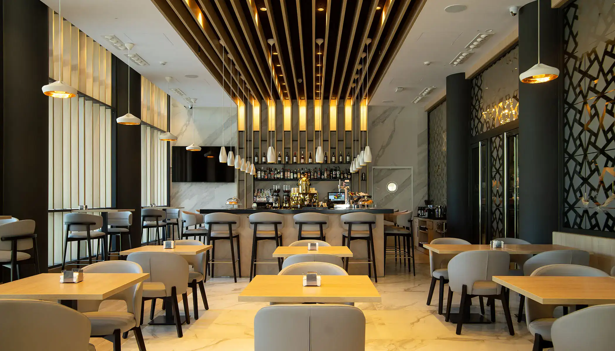 Restaurante moderno y elegante con iluminaci&oacute;n c&aacute;lida y barra de bebidas.