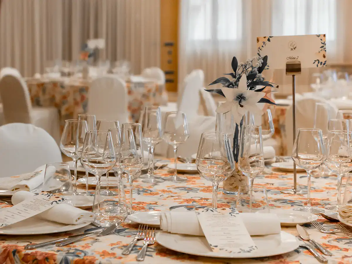 Mesa elegante con copas y flores para un evento formal.