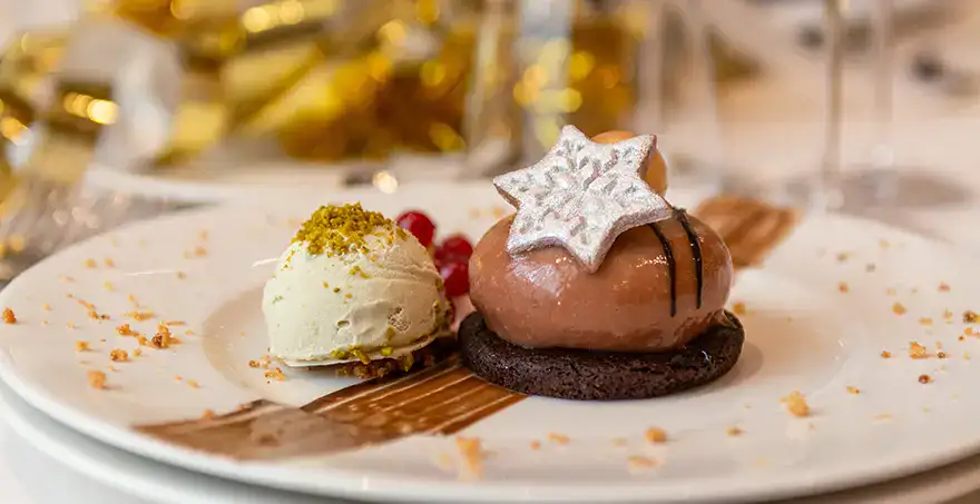 Postre elegante con helado y mousse decorado con estrella de chocolate.