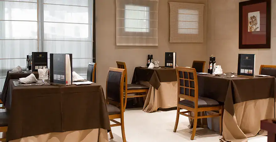 Restaurante elegante con mesas vestidas y sillas de madera.