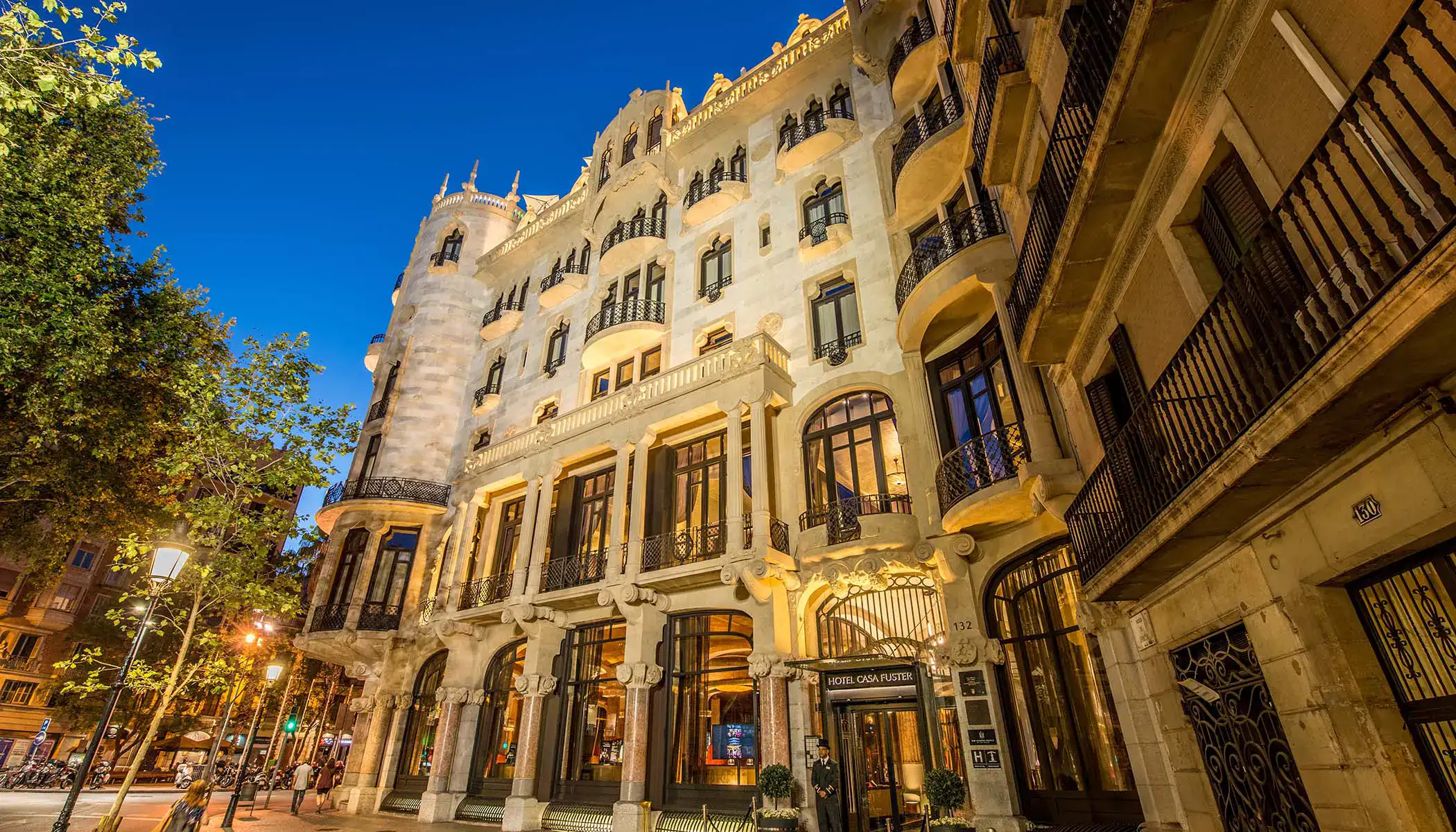 Edificio elegante y iluminado en una calle al anochecer.