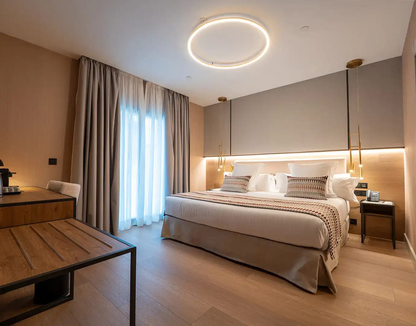 Habitaci&oacute;n de hotel elegantemente decorada con cama doble y luz tenue.