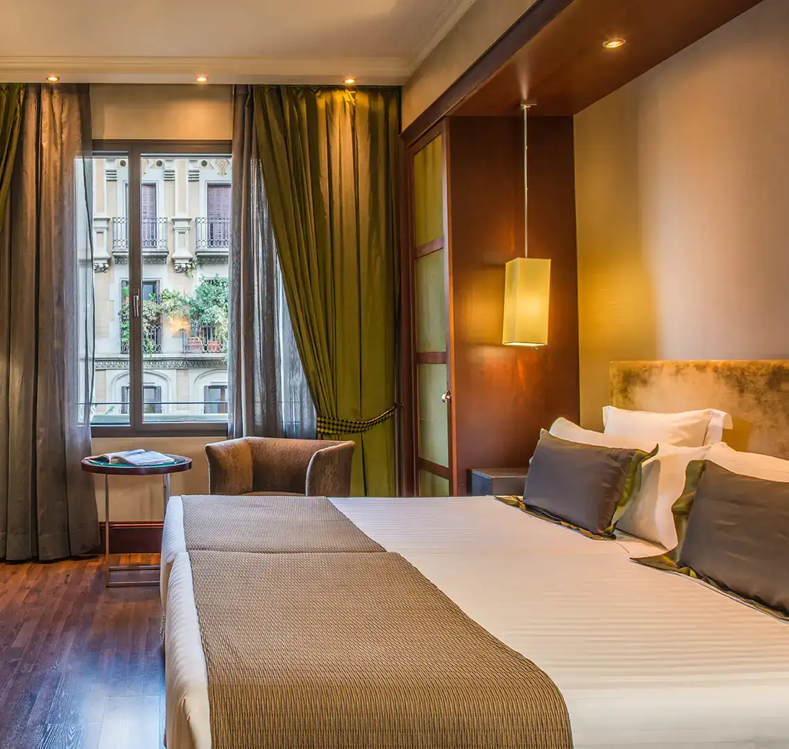 Habitaci&oacute;n elegante con cama doble y ventana con vista a la ciudad.