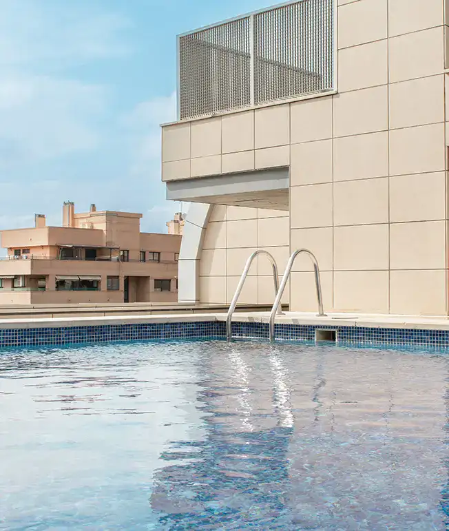 Piscina en la azotea de un edificio moderno con cielo despejado.