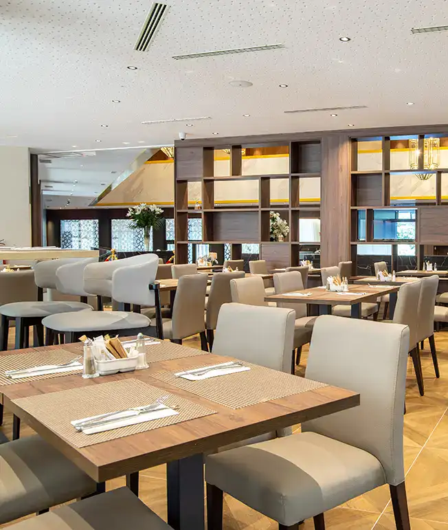 Restaurante moderno y elegante con mesas y sillas, decorado con flores.