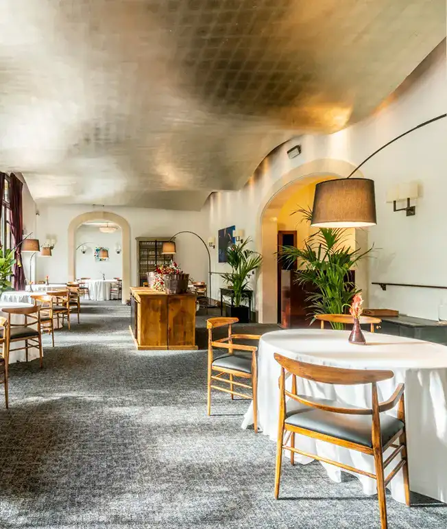 Restaurante elegante con mesas redondas y decoraci&oacute;n moderna.