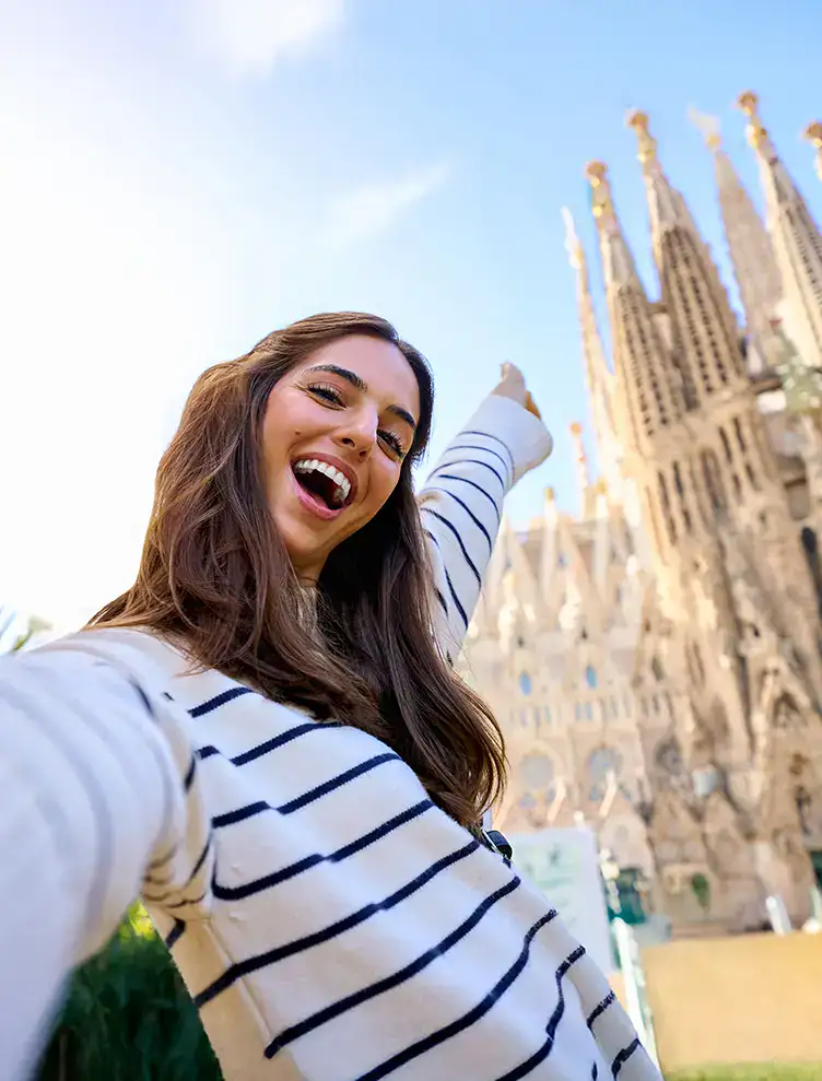 Mujer sonriente en selfie frente a un famoso monumento g&oacute;tico.
