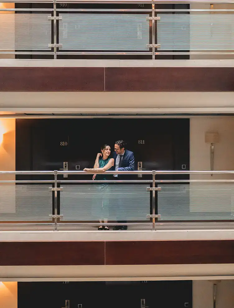 Pareja conversando en un pasillo de hotel, frente a las habitaciones 810 y 811.