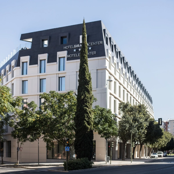 Edificio moderno del Hotel Center con &aacute;rboles y calle frente a &eacute;l.