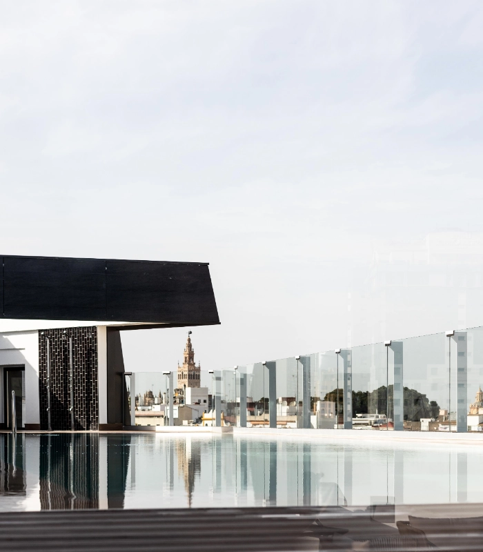 Piscina en azotea con vistas a una catedral en la ciudad al fondo.