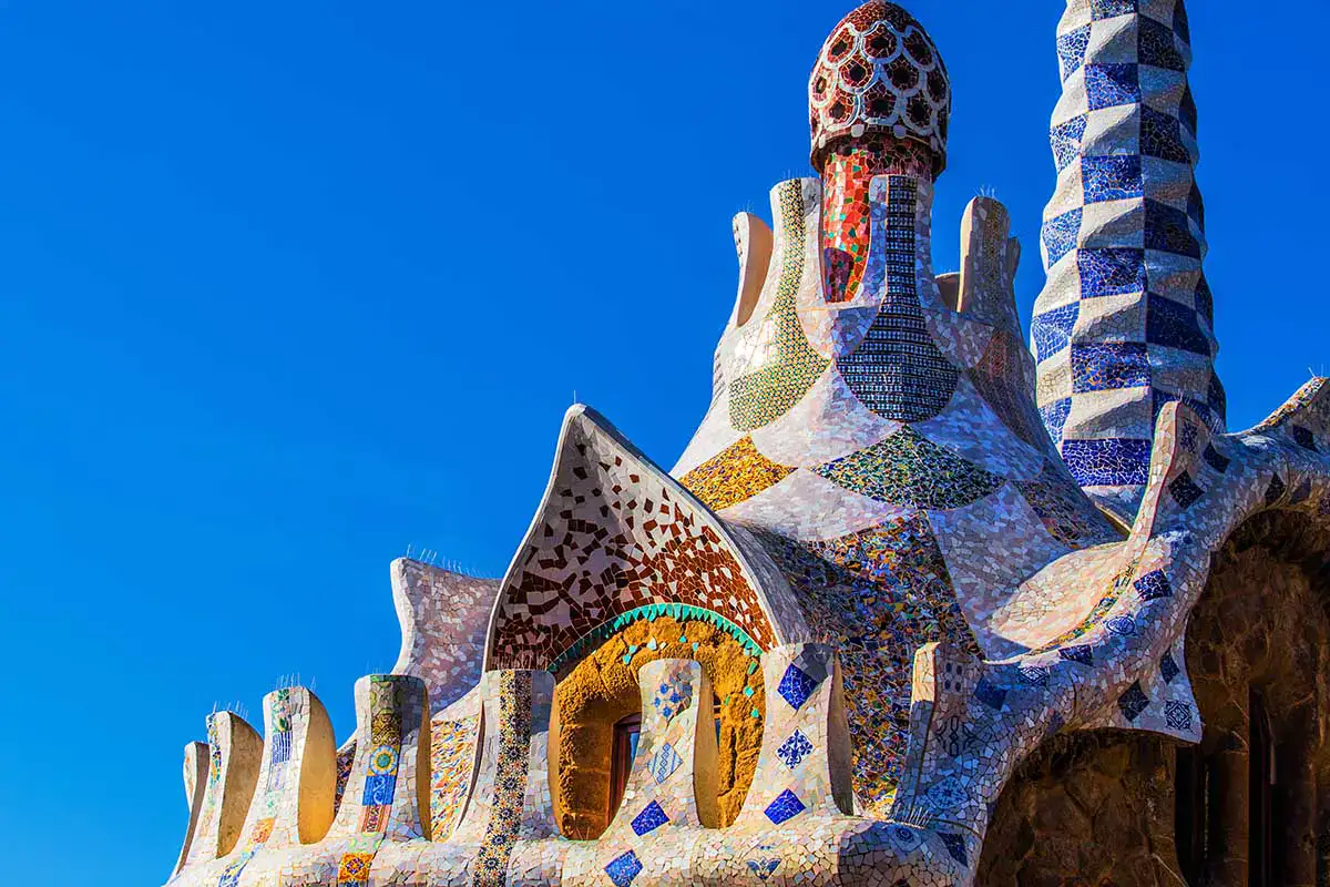 Edificio de Gaud&iacute; con mosaicos coloridos y cielo azul de fondo.