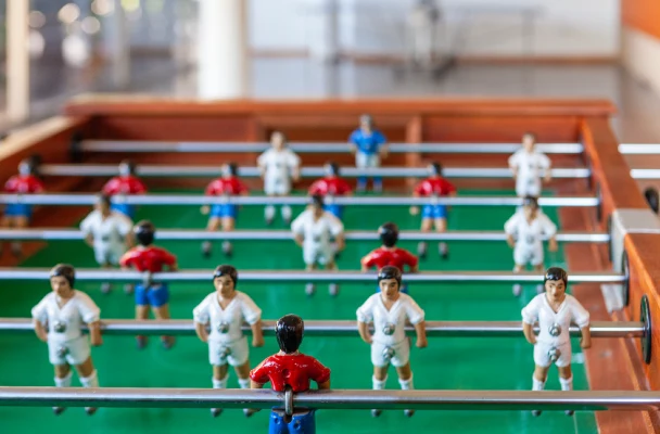 Jugadores de futbol&iacute;n en un campo verde; equipos con camisetas blancas y rojas.