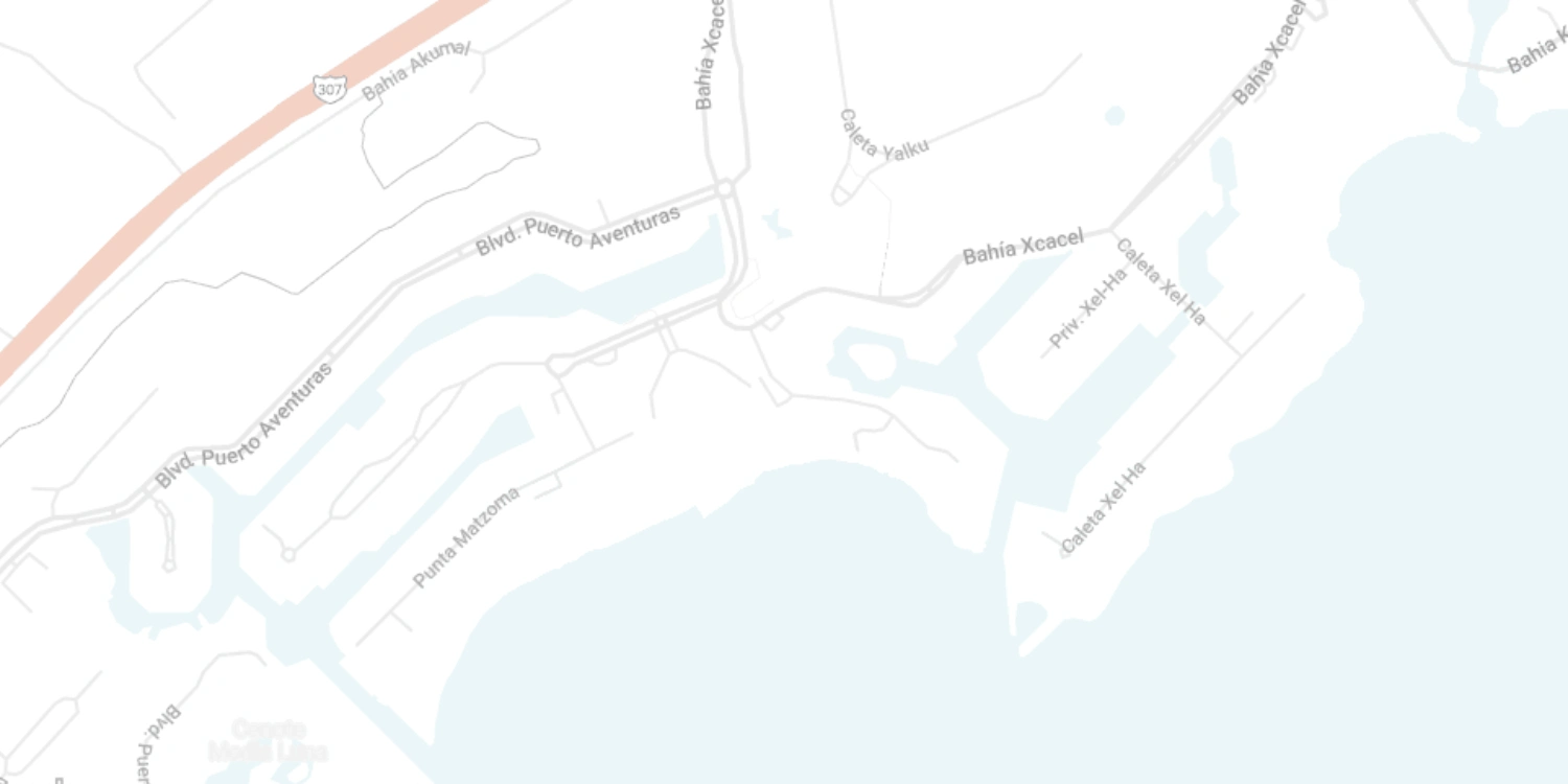 Mapa de calles en Puerto Aventuras con carreteras y bahías visibles.