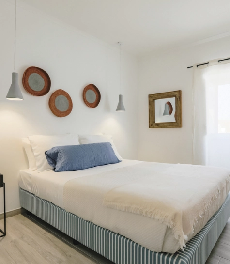 Quarto moderno e aconchegante com cama de casal, decoração minimalista e luz natural.