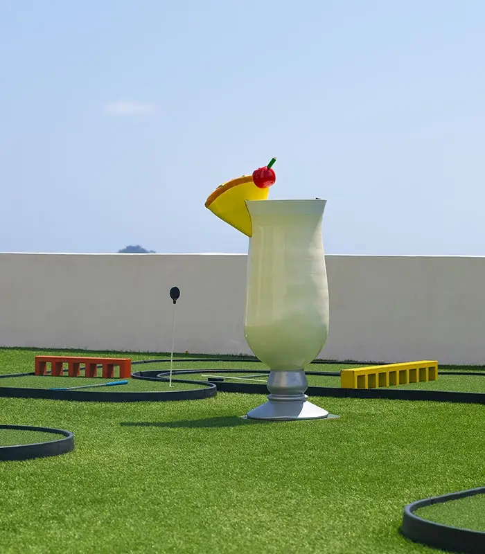Escultura de granizado de fruta en un campo de minigolf sobre c&eacute;sped artificial.