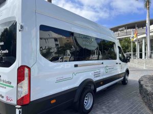 Furgoneta blanca de la Asociaci&oacute;n Espa&ntilde;ola contra el C&aacute;ncer frente a un hotel.