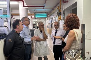 Un grupo de personas conversa en un pasillo, con uno de ellos vestido de chef y otros de civil.