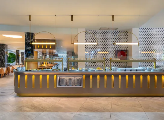 Bufé moderno con iluminación cálida y vajilla organizada en un restaurante elegante.