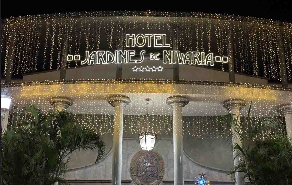 Fachada del Hotel Jardines de Nivaria iluminada con luces colgantes y columnas decorativas.
