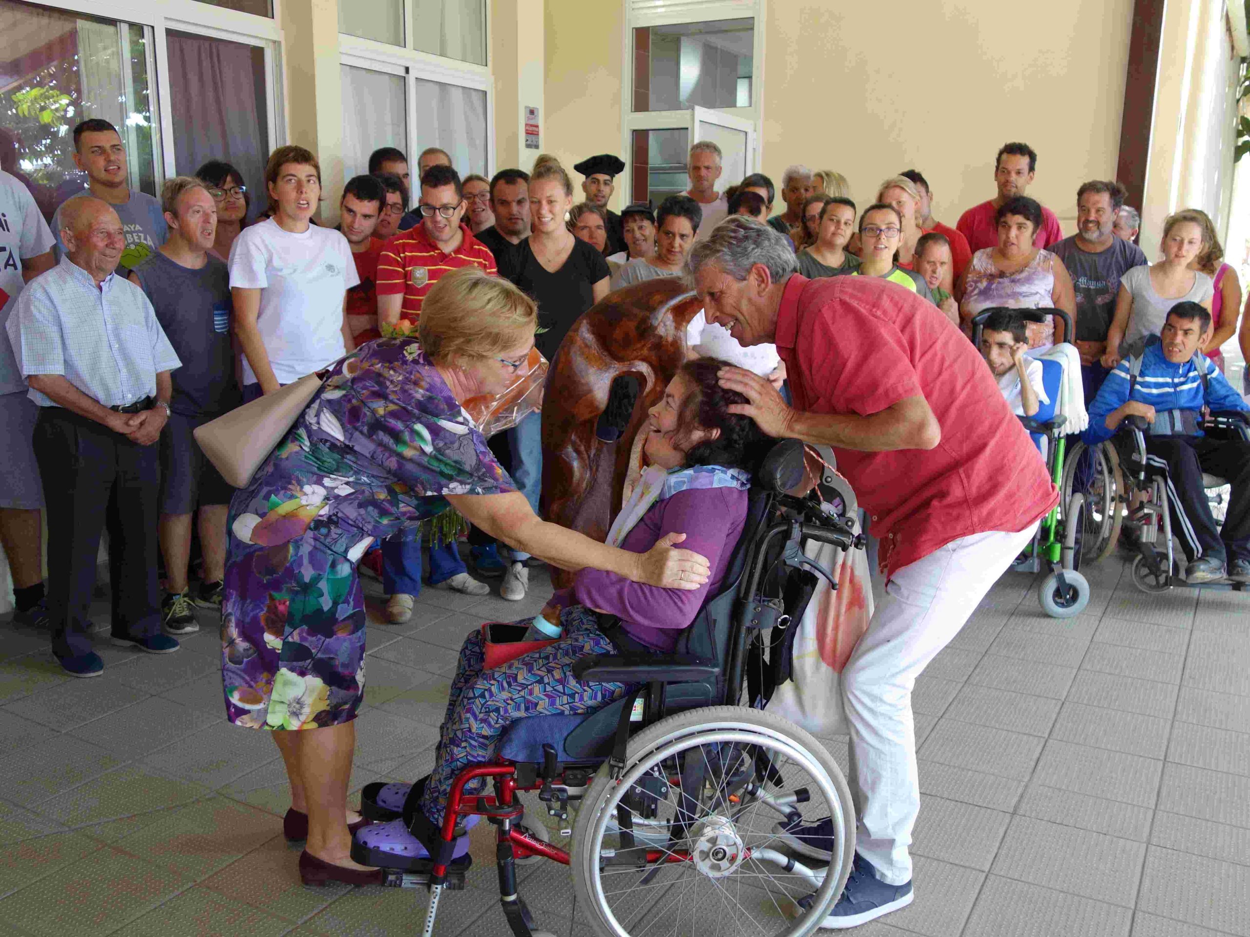 Grupo diverso de personas reunidas en un evento, mostrando afecto y apoyo.