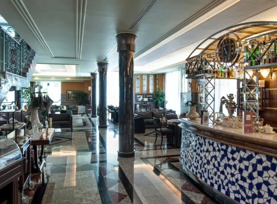 Bar elegante con barra de azulejos azules y blancos y muebles de salón.