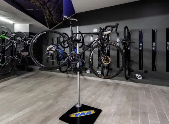 Sala de bicicletas con varias bicicletas colgadas en la pared y una en un soporte central.