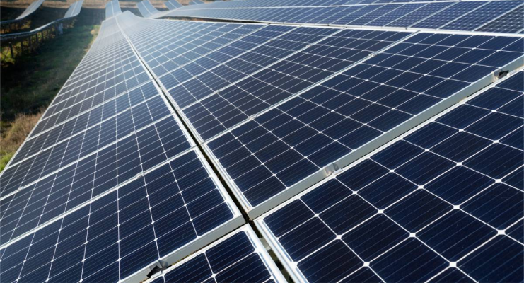 Paneles solares alineados en un campo bajo el sol.