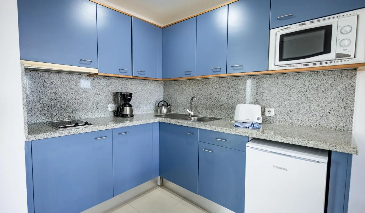 Cocina moderna con gabinetes azules y electrodomésticos.