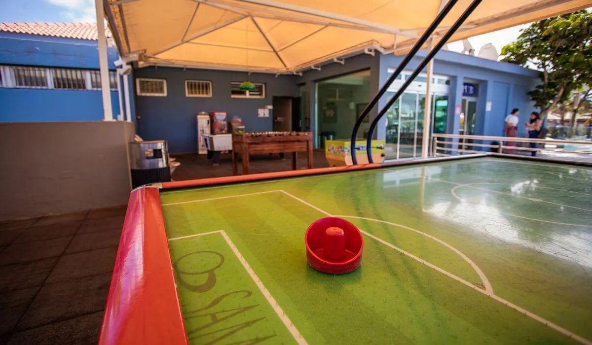 Mesa de air hockey al aire libre bajo techo amarillo.