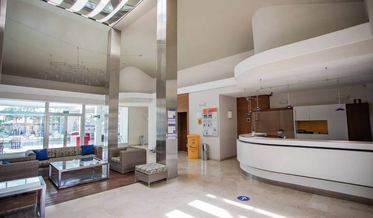 Hall de hotel moderno con recepción y sofás.