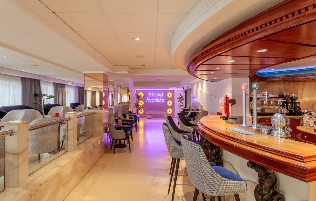 Bar y área de estar moderna en un hotel elegante y luminoso.