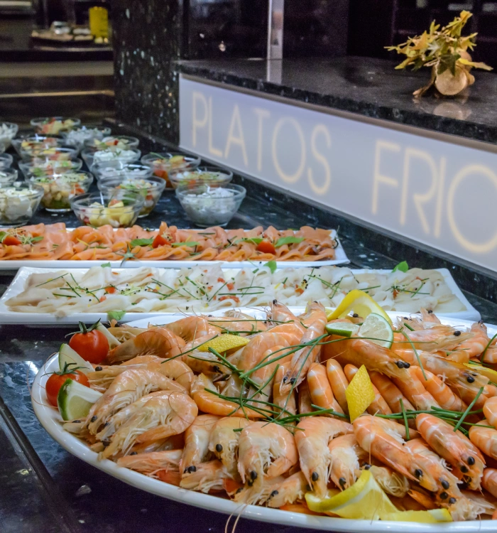 Buffet de mariscos y ensaladas bajo letrero de "Platos Fríos".