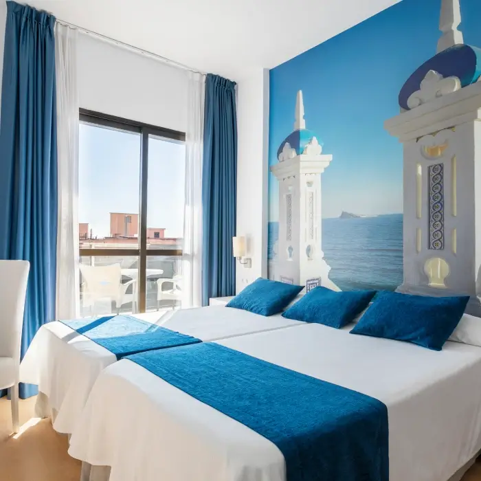 Habitación luminosa con decoración azul y vista al exterior.