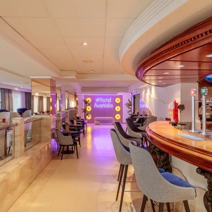 Bar en el lobby de un hotel moderno con luces y decoración elegante.