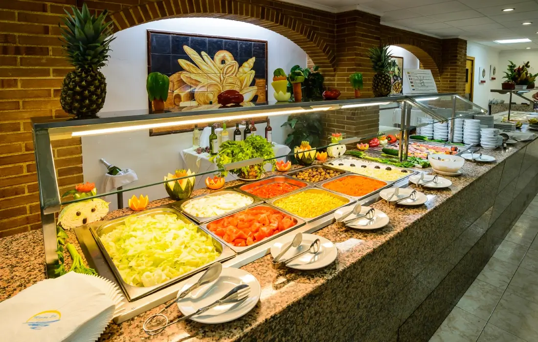 Buffet de ensaladas con variedad de ingredientes y decoración colorida.