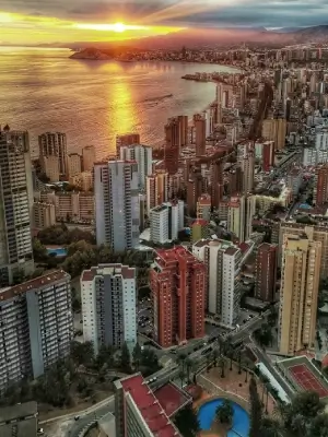 Vista aérea del atardecer en una ciudad costera con muchos edificios altos.