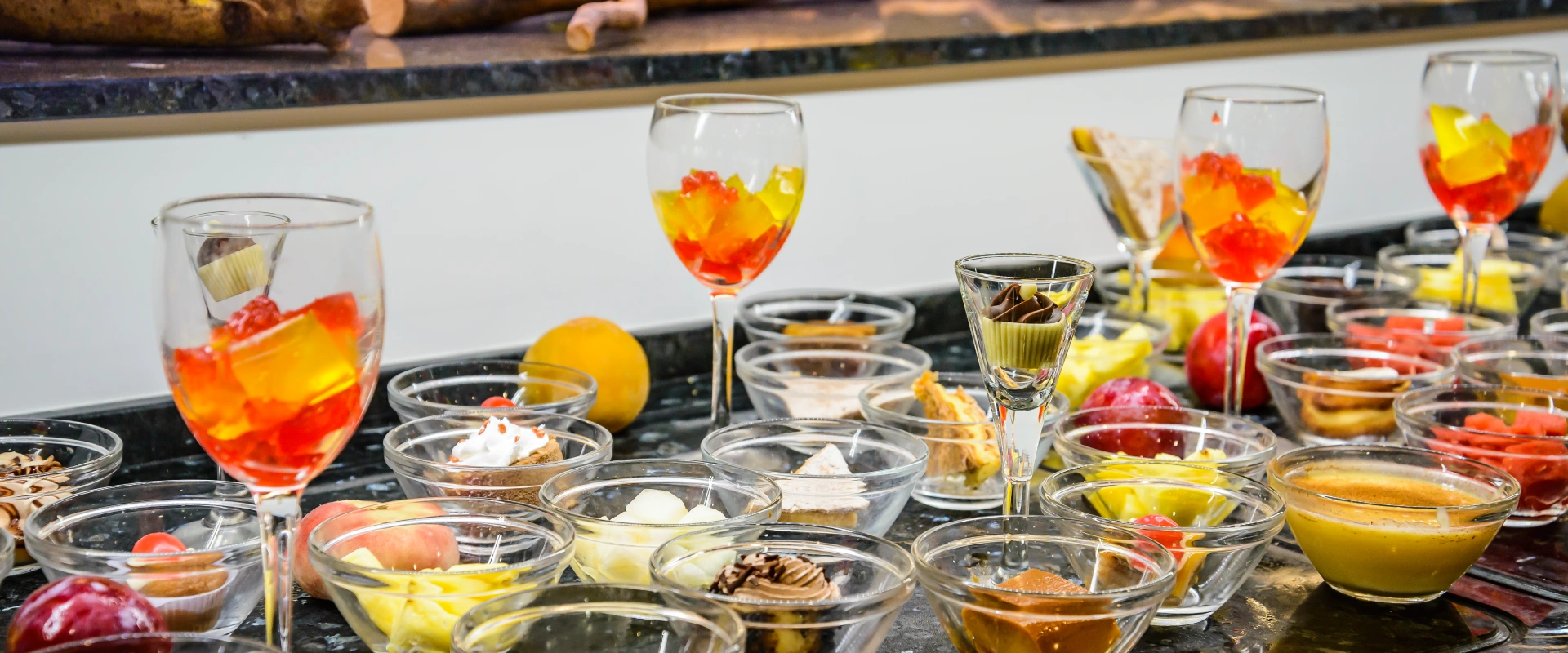 Postres surtidos en copas y platos pequeños sobre una mesa.