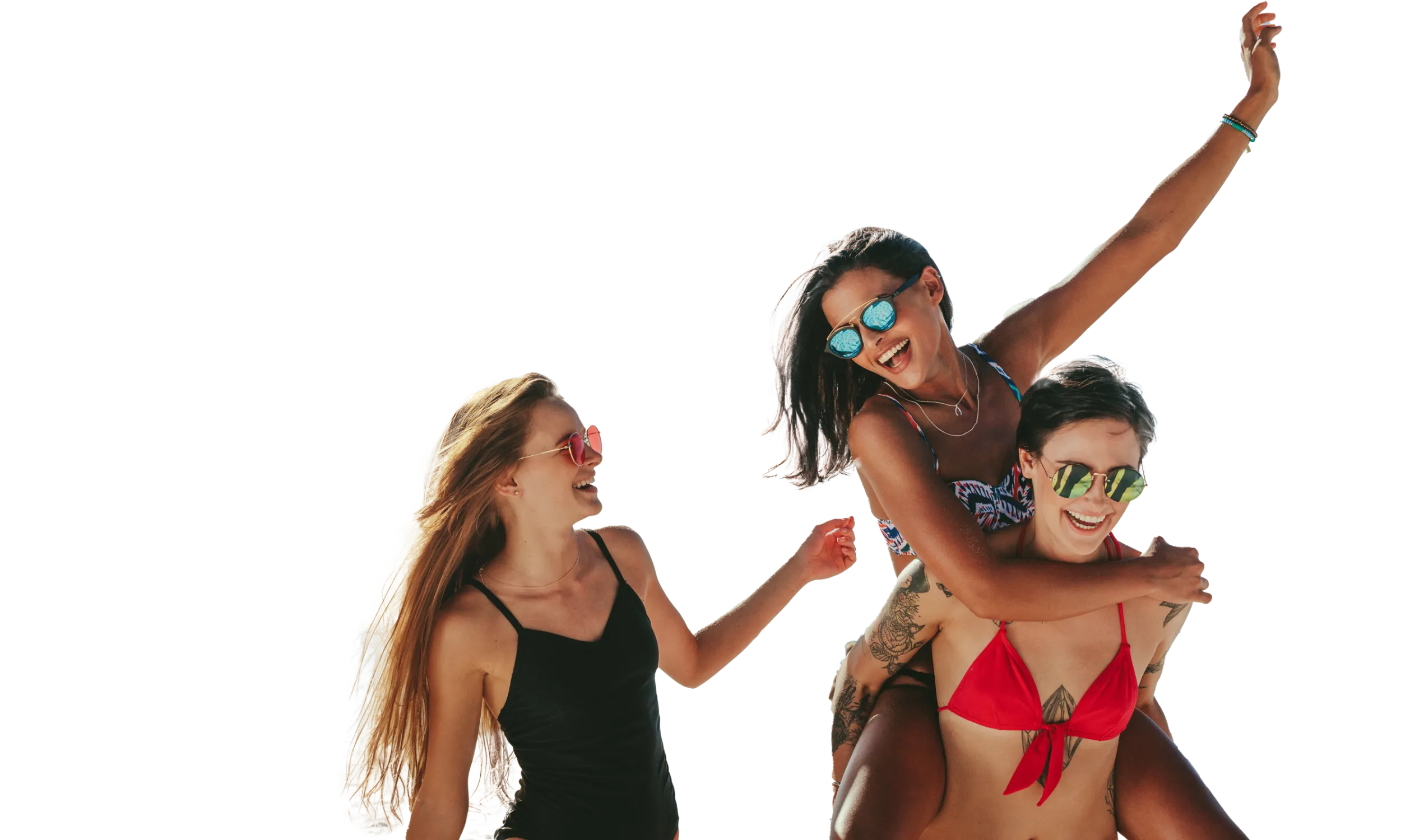 Tres personas riendo en la playa, usando gafas de sol y trajes de baño coloridos.