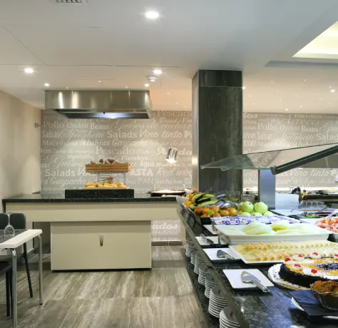 Buffet de comida con platos variados y decoración de palabras en las paredes.