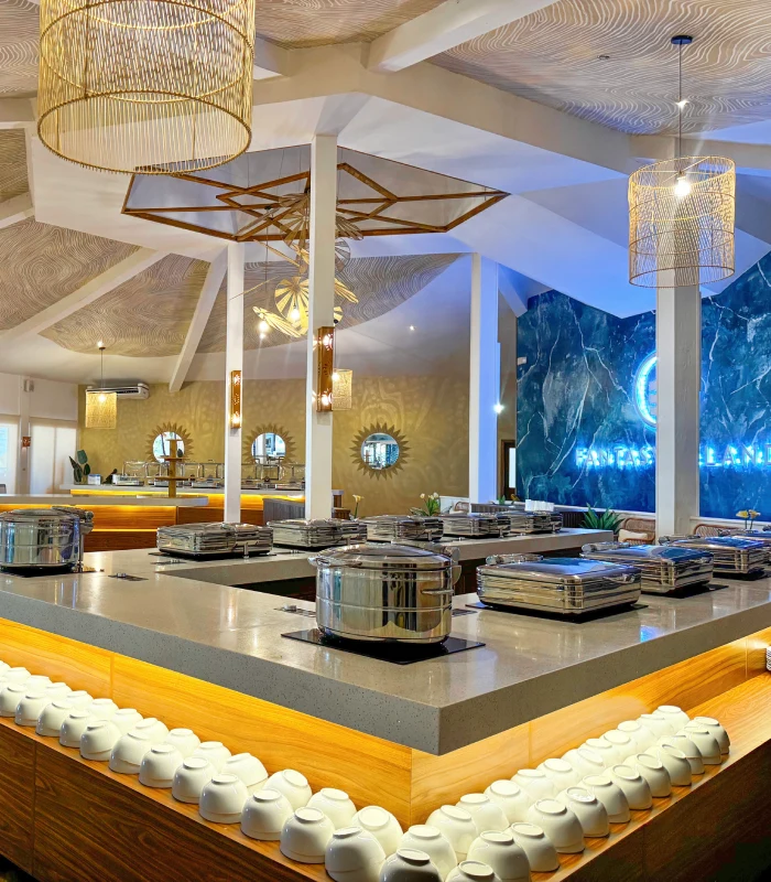 Restaurante moderno con mesas buffet, vajilla y lámparas colgantes.