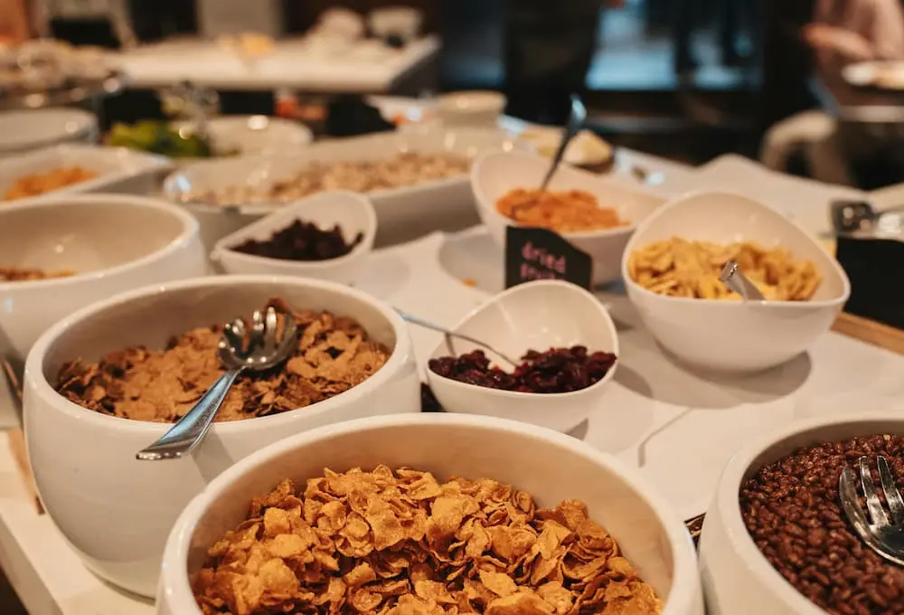 Assortiment de céréales et fruits secs dans des bols au petit-déjeuner.