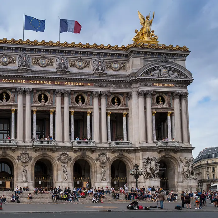 Fa&ccedil;ade orn&eacute;e de l'op&eacute;ra Garnier avec sculptures et coupole verte.