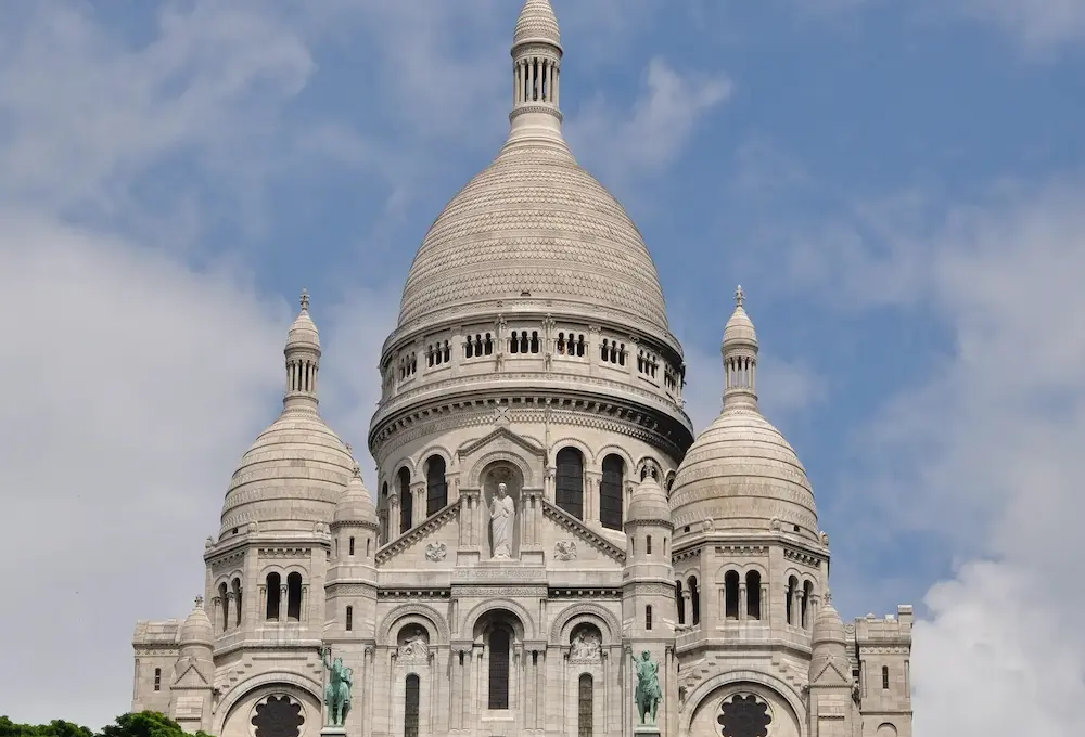 Basilique avec dômes sous un ciel bleu partiellement nuageux.