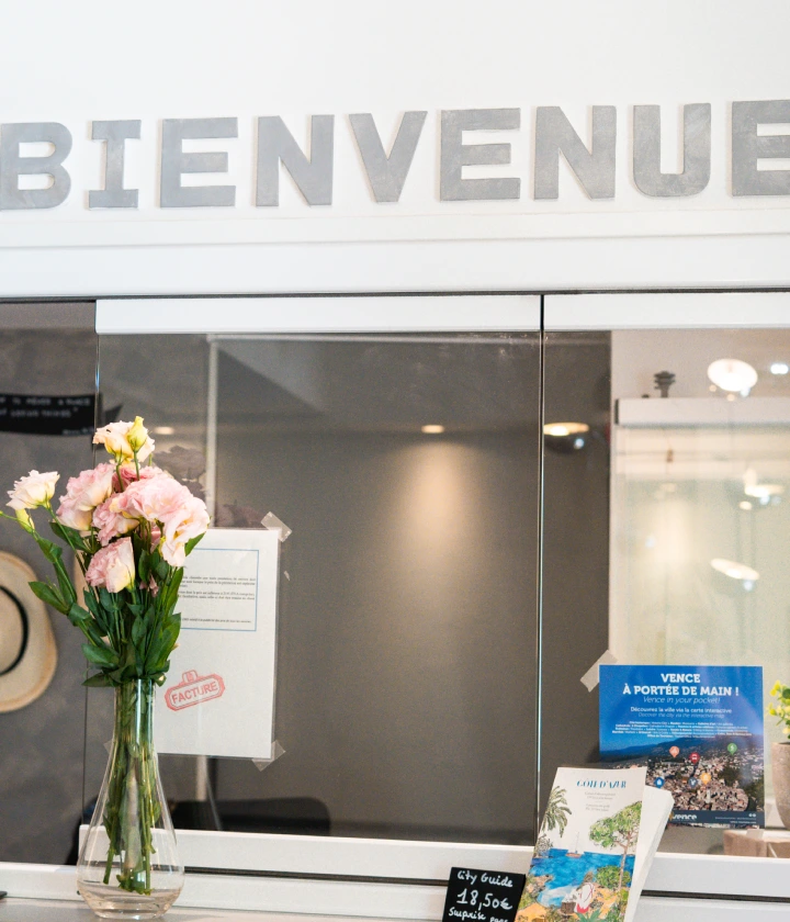 Bureau d'accueil avec bouquet de fleurs sous un panneau "Bienvenue".
