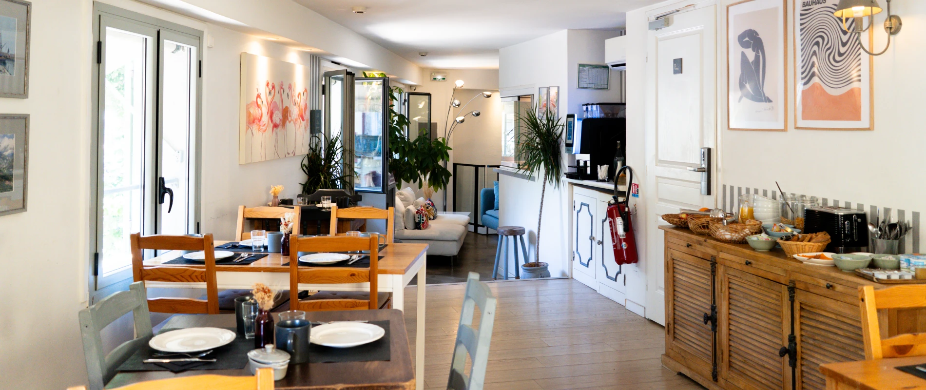 Salle à manger lumineuse avec tables dressées et décoration moderne.