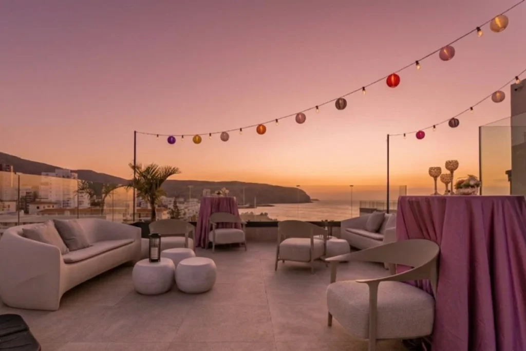 Terraza lounge decorada con guirnaldas durante el atardecer en Los Cristianos.