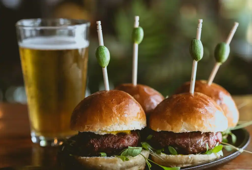 Mini hamburguesas gourmet y vaso de cerveza fr&iacute;a durante el evento de tardeo con DJ en el Rooftop de Los Cristianos, Tenerife Sur