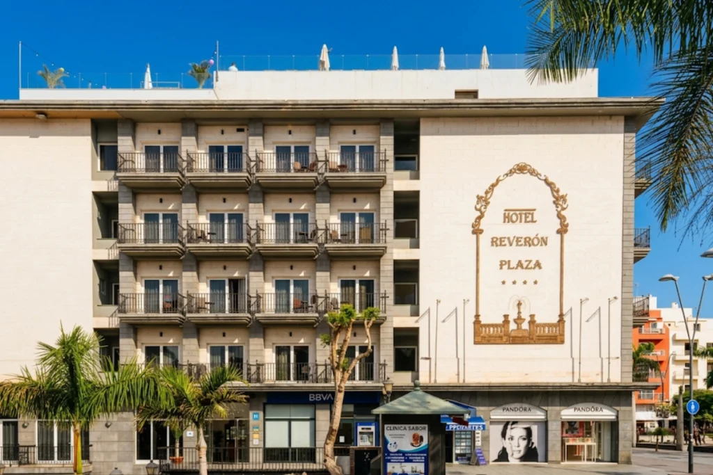 Fachada principal del Hotel Rever&oacute;n Plaza con balcones de forja y su gran logotipo dorado.