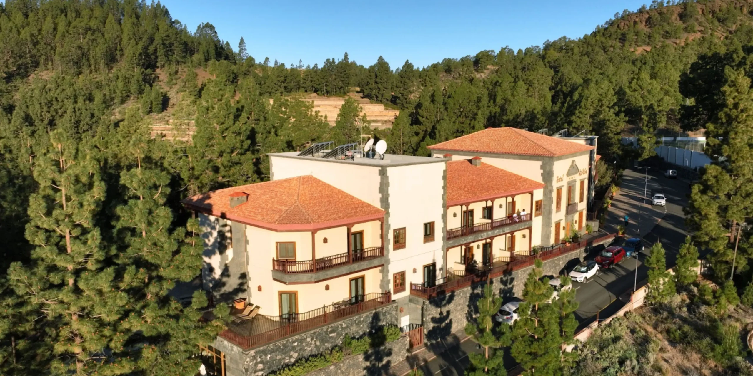 Vista aérea de la fachada tradicional del Hotel Spa Villalba rodeado de un espeso pinar en Vilaflor.